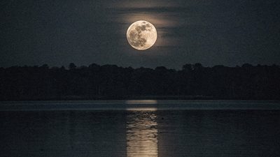 Убывающая луна над тёмным озером, лунный календарь на июнь для практик и ритуалов отпускания
