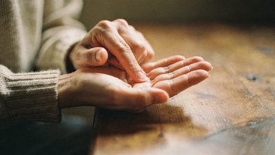Раскрытая ладонь крупным планом, хиромант читает линии на руке во время консультации