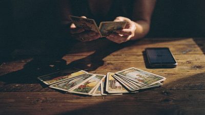 Женщина у ноутбука раскладывает карты таро, онлайн-гадание на выбор между двумя вариантами